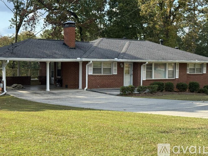 A brick house with a covered porch and a chimney.