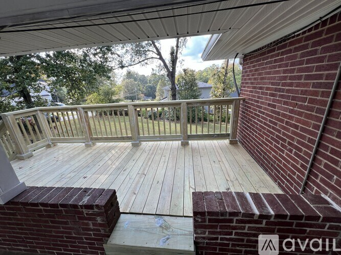 A wooden deck with a brick wall and a metal railing.