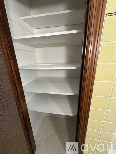 Empty white shelves in a refrigerator.