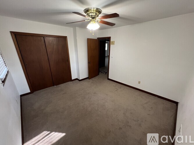 A room with a ceiling fan and two doors.