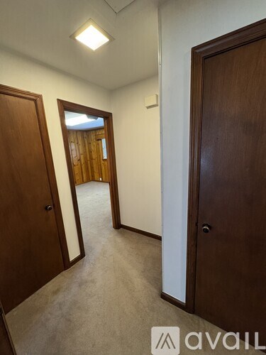 A hallway with two doors on either side and a window in the middle.