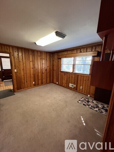 A room with wooden walls and a carpeted floor.
