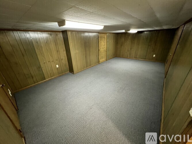 A room with wooden walls and carpeted floor.