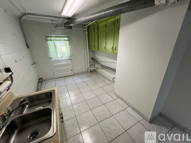 A kitchen with a sink and green cabinets.