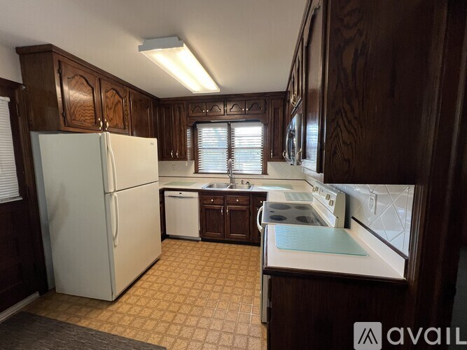 A kitchen with wooden cabinets and a white refrigerator.
