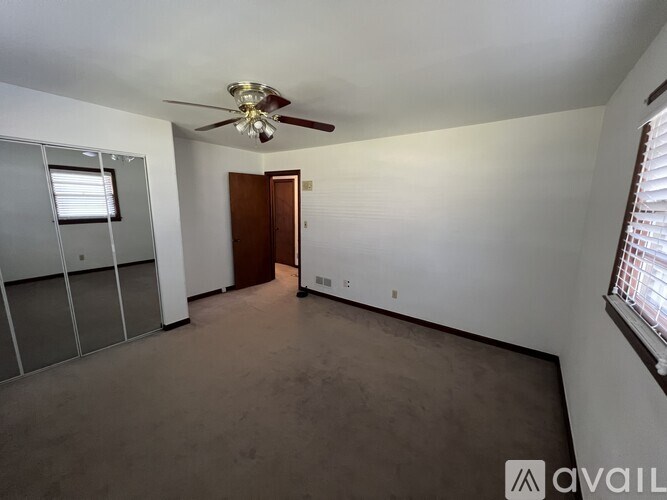 A room with a ceiling fan and a door is available for rent.