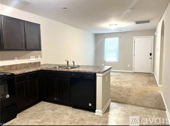 A kitchen with black cabinets and a granite countertop.