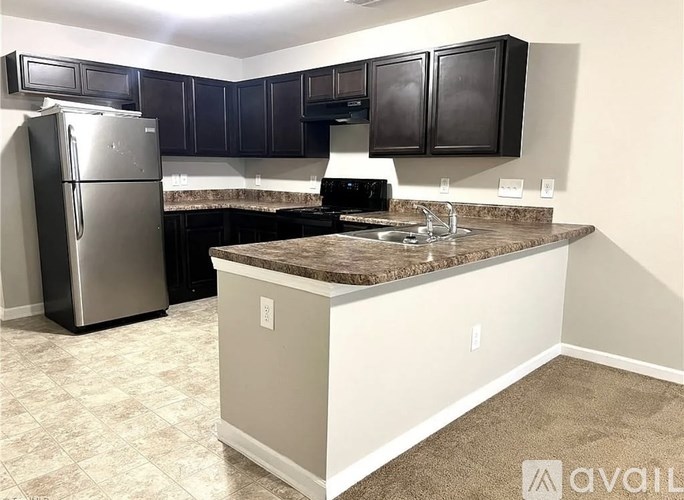 A kitchen with a granite countertop and a refrigerator.