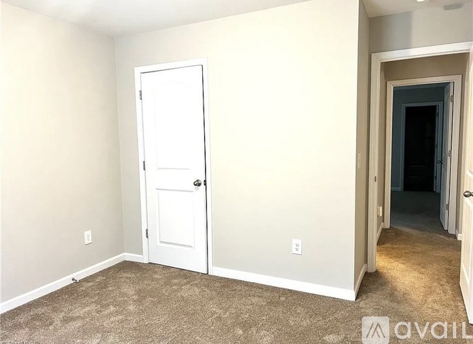 A room with a white door and carpeted floor.