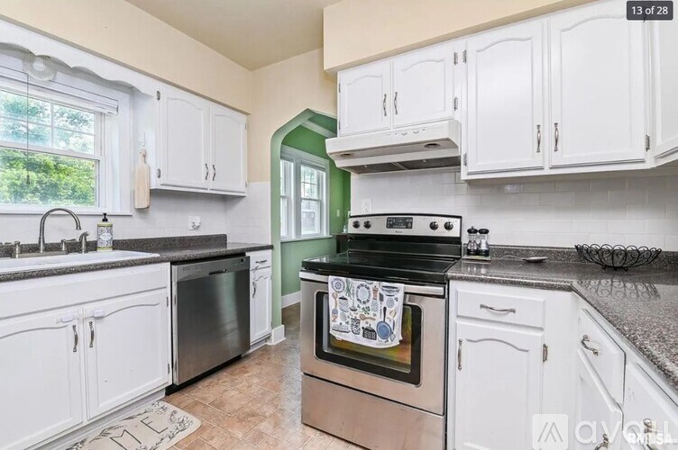 A kitchen with white cabinets and a black stove top oven.