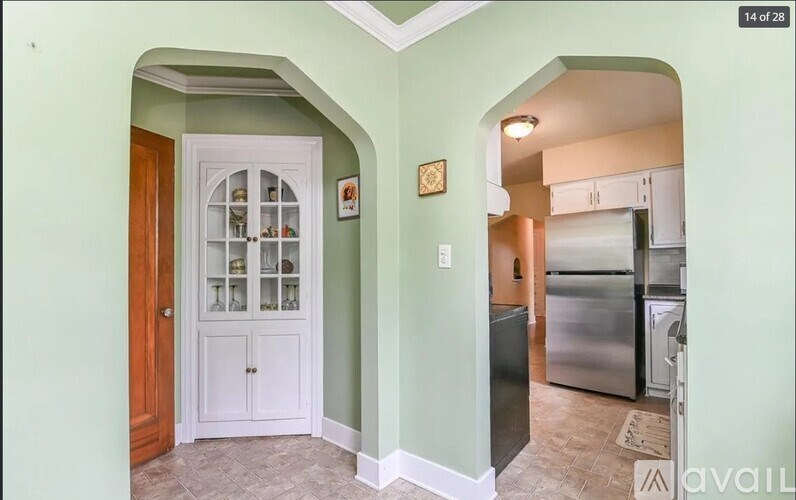 A kitchen with a white door and a fridge.