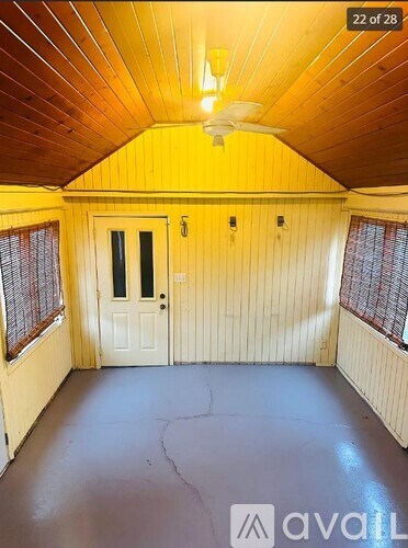A room with wooden walls and a ceiling fan.