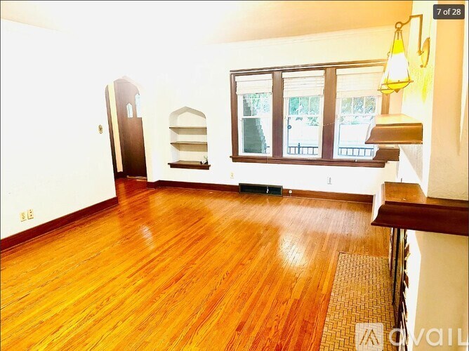 A room with wooden floors and a large window.