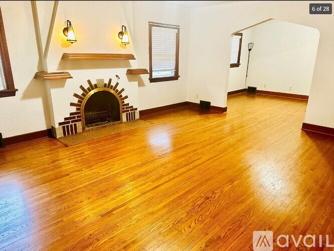 A room with a fireplace and wooden floors.