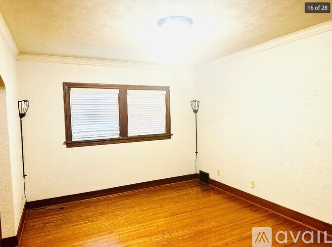 A room with a window and two lamps on either side.