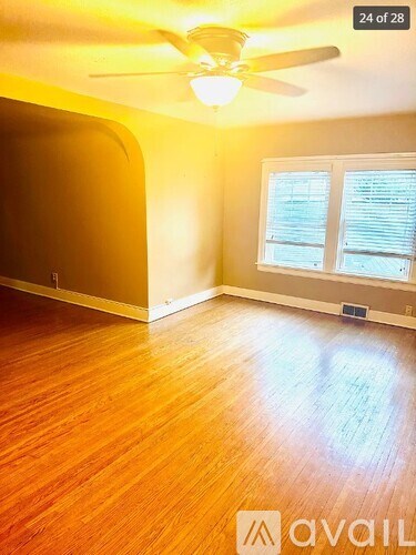 A room with a ceiling fan and wooden flooring.
