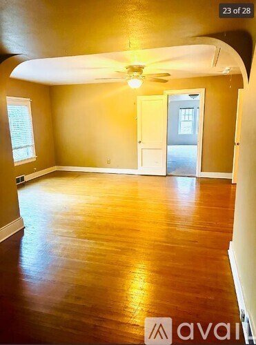 A room with wooden floors and a ceiling fan.