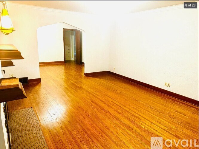 A room with wooden flooring and a white wall.