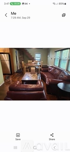A living room with a brown leather sofa and a wooden coffee table.