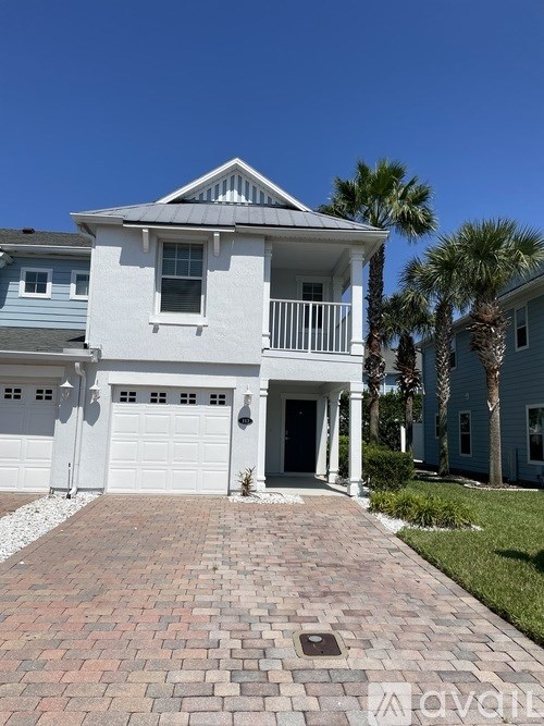 A white house with a brick pathway leading to the front door.
