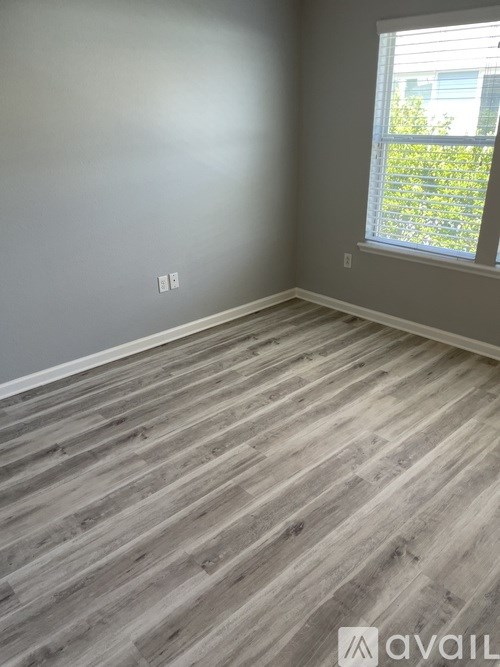 A room with wooden flooring and a window.
