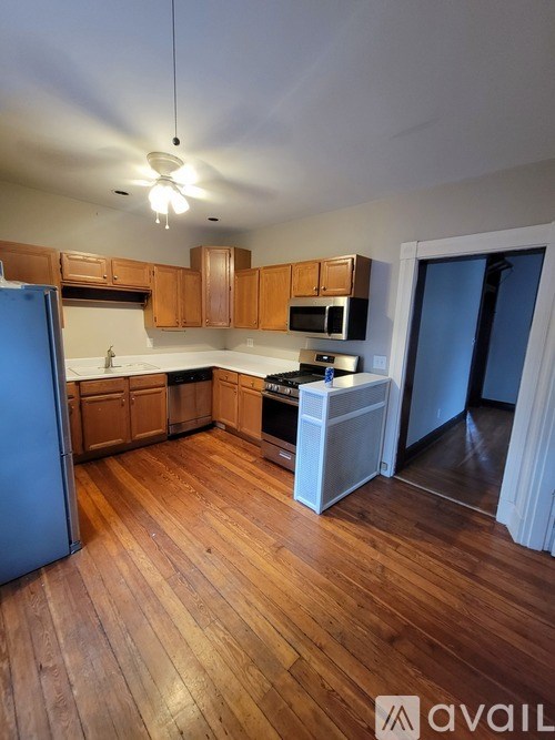 A kitchen with wooden floors and a blue refrigerator.