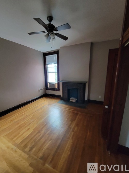 A room with a fireplace and a ceiling fan.