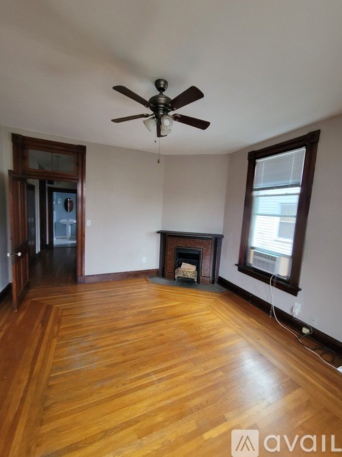 A room with a fireplace and a ceiling fan.