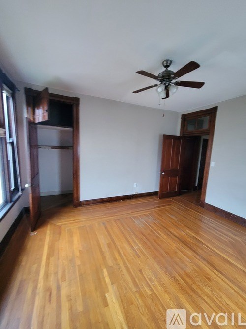 A room with wooden floors and a ceiling fan.