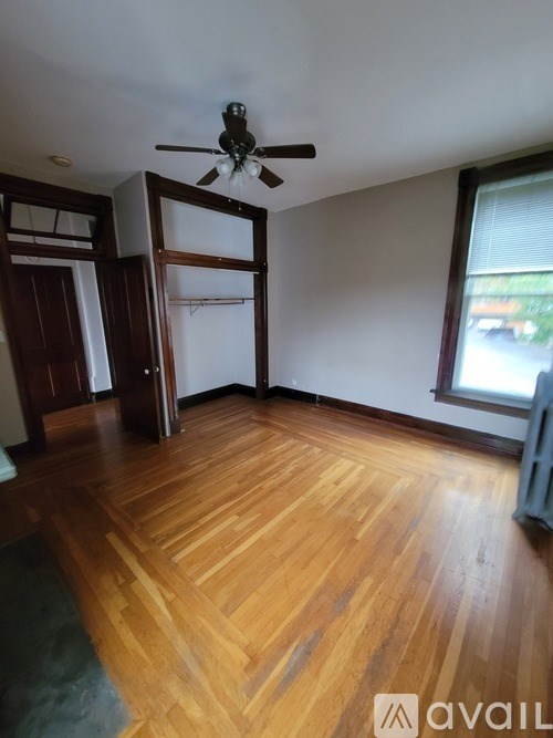 A room with wooden flooring and a ceiling fan.