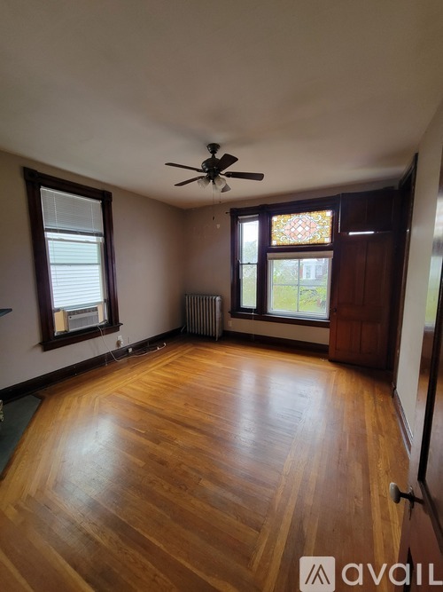 A room with wooden floors and a ceiling fan.