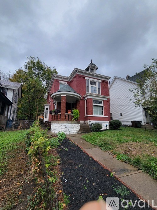 A red brick house with a white garage and a white house in the background.