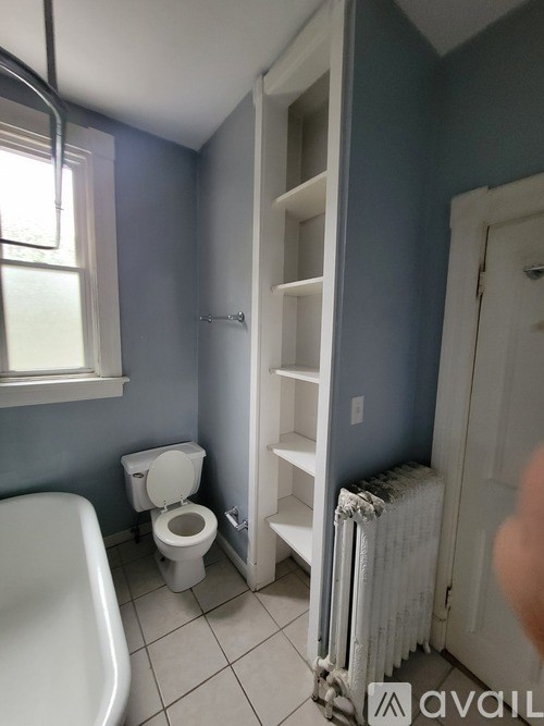 A bathroom with a toilet, a bathtub, and a radiator.
