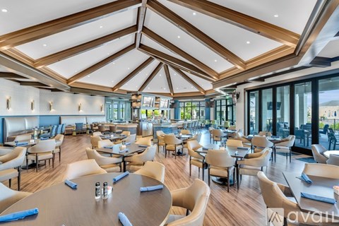 A spacious dining area with wooden tables and chairs.