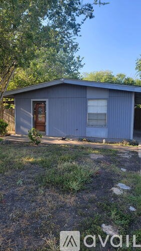 A blue house with a brown door and a window is for sale.