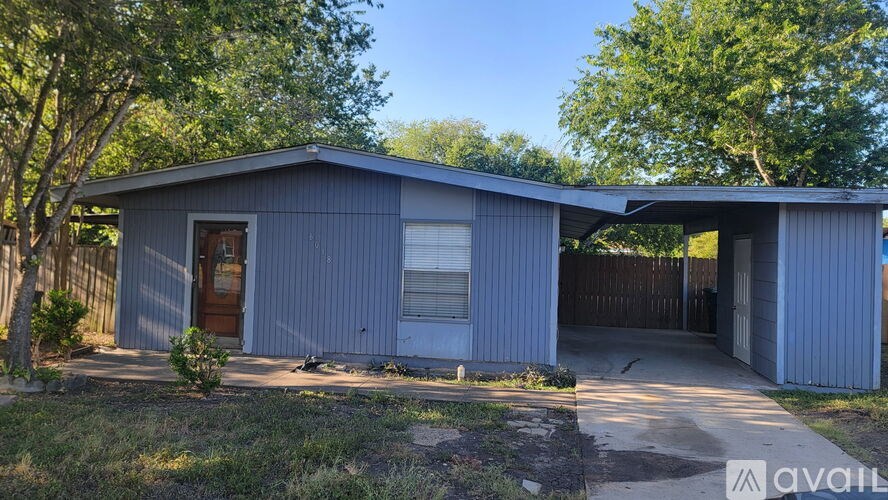 A blue house with a brown door and a brown fence.