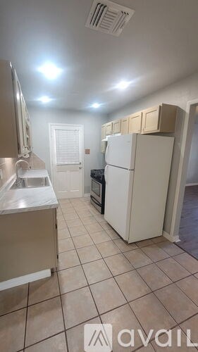 A kitchen with white appliances and cabinets is available for rent.