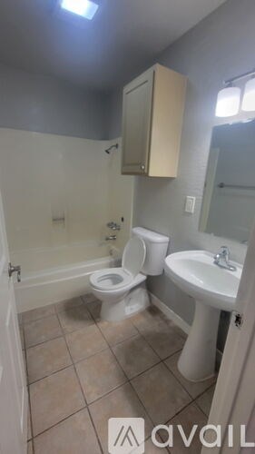 A bathroom with a toilet, sink, and mirror.