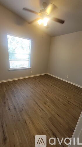A room with wooden flooring and a window.