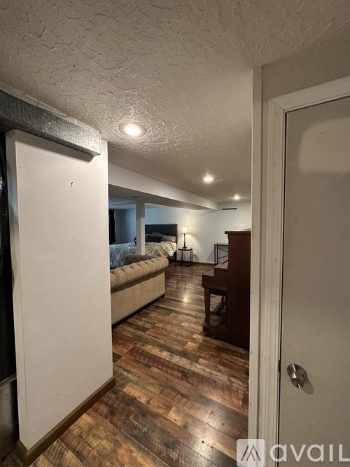 A hallway with a wooden floor and a white door.