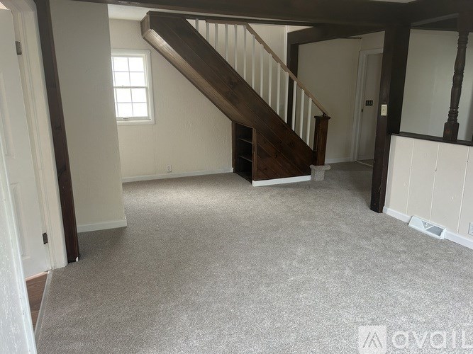 A spacious room with a staircase leading to the upper floor.