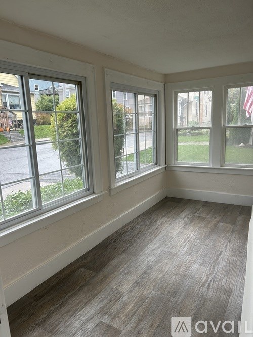 A room with a large window and a grey carpet.