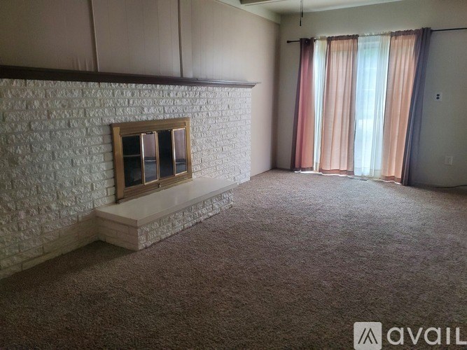 A room with a fireplace and carpeted floor.