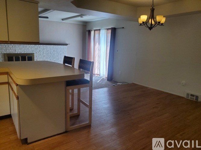 A kitchen with a bar stool and a chandelier.
