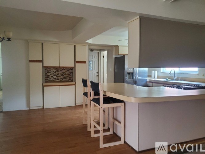 A kitchen with a bar stool and a counter.
