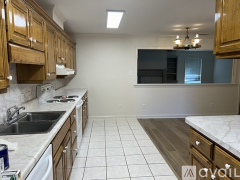 A kitchen with wooden cabinets and a marble countertop.
