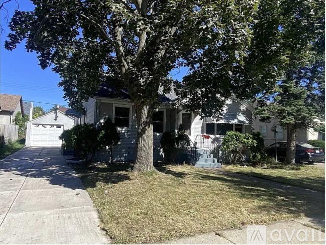 A tree in front of a house with a sign that says "available".