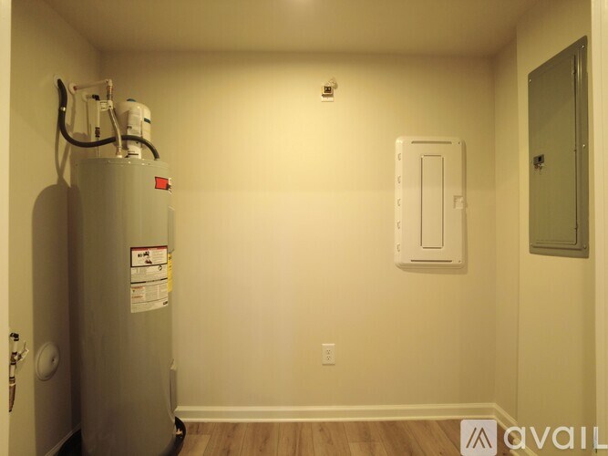 A room with a water heater and a door.