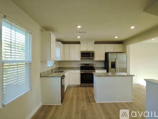 A modern kitchen with white cabinets and a central island.