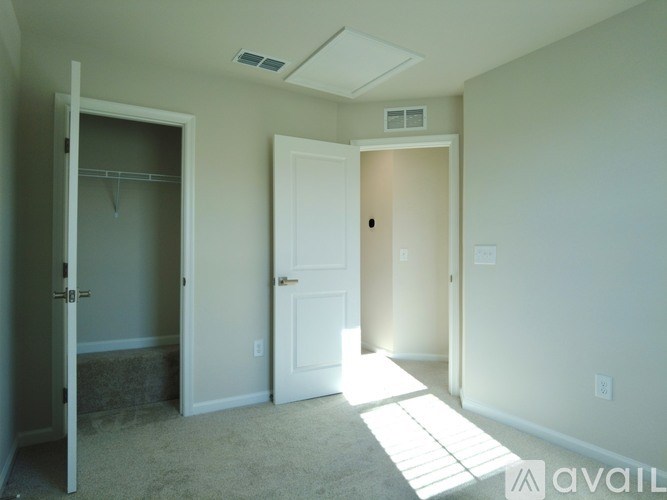 A room with a door and a window letting in sunlight.